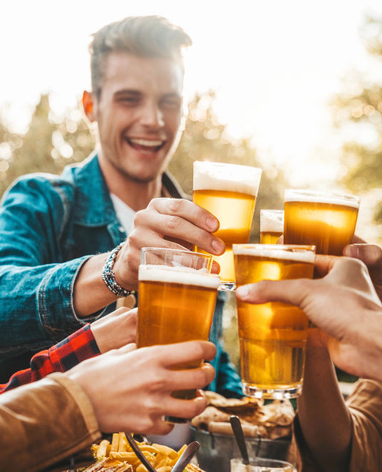 Mit Bier anstossende Menschen